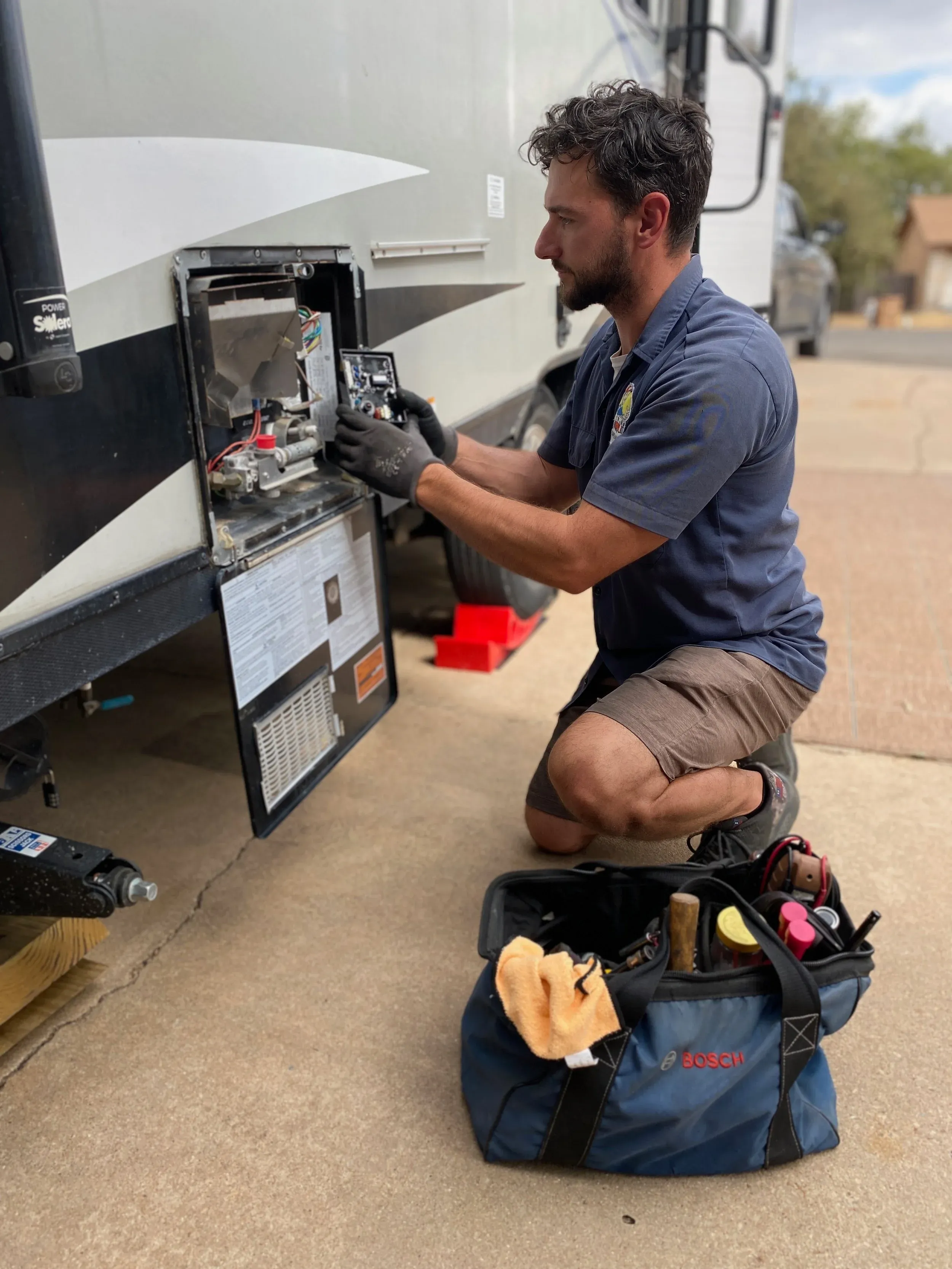 Mobile RV repair technician servicing a motorhome on-site in the East Valley